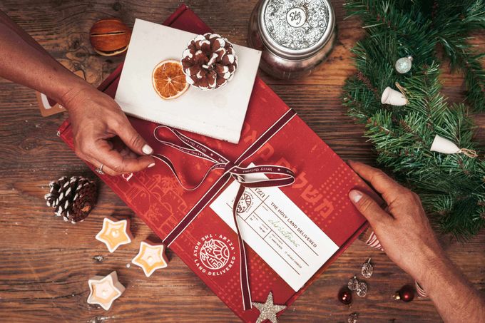 Artza subscription gift box from the holy land a person opening a christmas present on a table