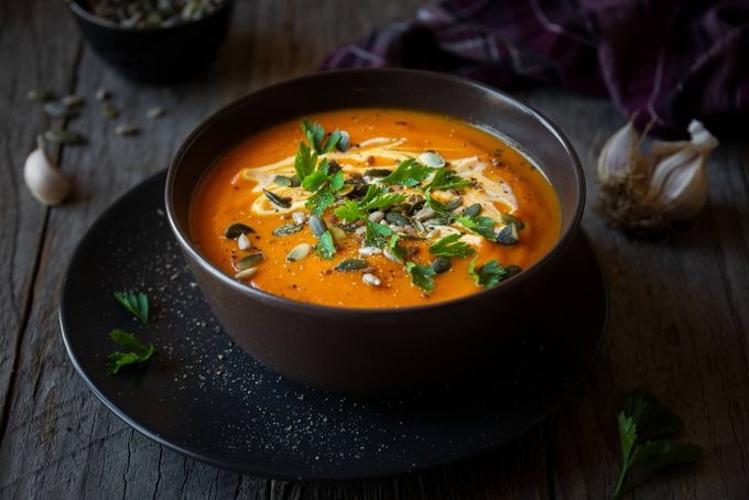 a bowl of soup on a black plate