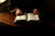 A person sitting at a table with an open Bible.