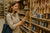 A woman looking at a wooden plaque.