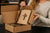 A woman opening a box with a cross on it.