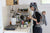 a woman holding a baby in a sling in a kitchen
