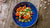 a blue bowl filled with vegetables on top of a wooden table