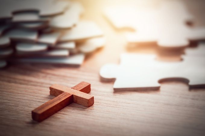 Small wooden cross and puzzle pieces