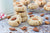 a stack of almond cookies next to a glass of milk