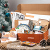 Open box from Arza with holiday-themed items including a Christmas tree in the background.